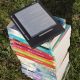 ereader placed on top of a pile of printed books